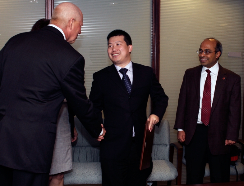 Professor Yan Yao shakes Dean Tedesco's hand after receiving the Ralph E. Powe Junior Faculty Enhancement Award.
