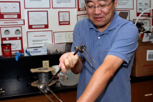 Professor Ji Chen shows example of metallic implantable device which he will test for compatibility with an MRI machine.